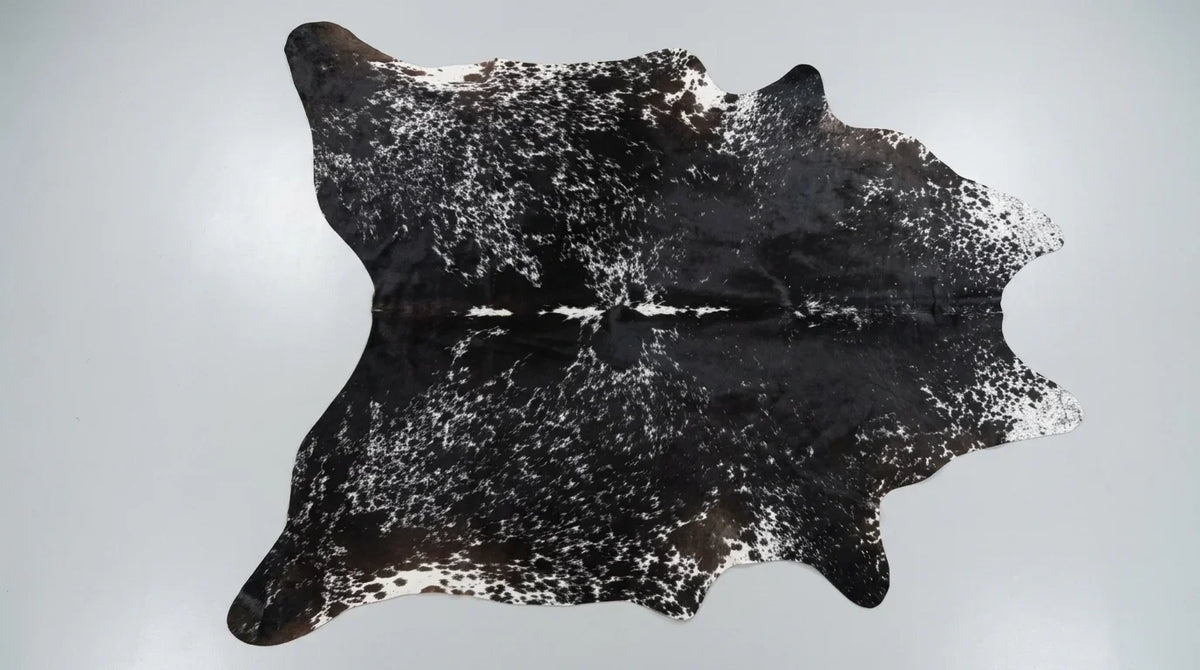 Black and White cowhide rug flat lay on white background showing full hide shape
