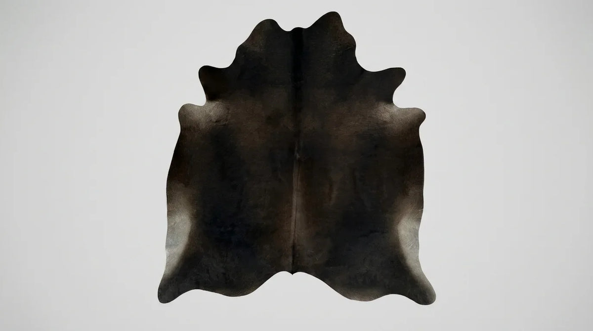 Black and White cowhide rug flat lay on white background showing full hide shape