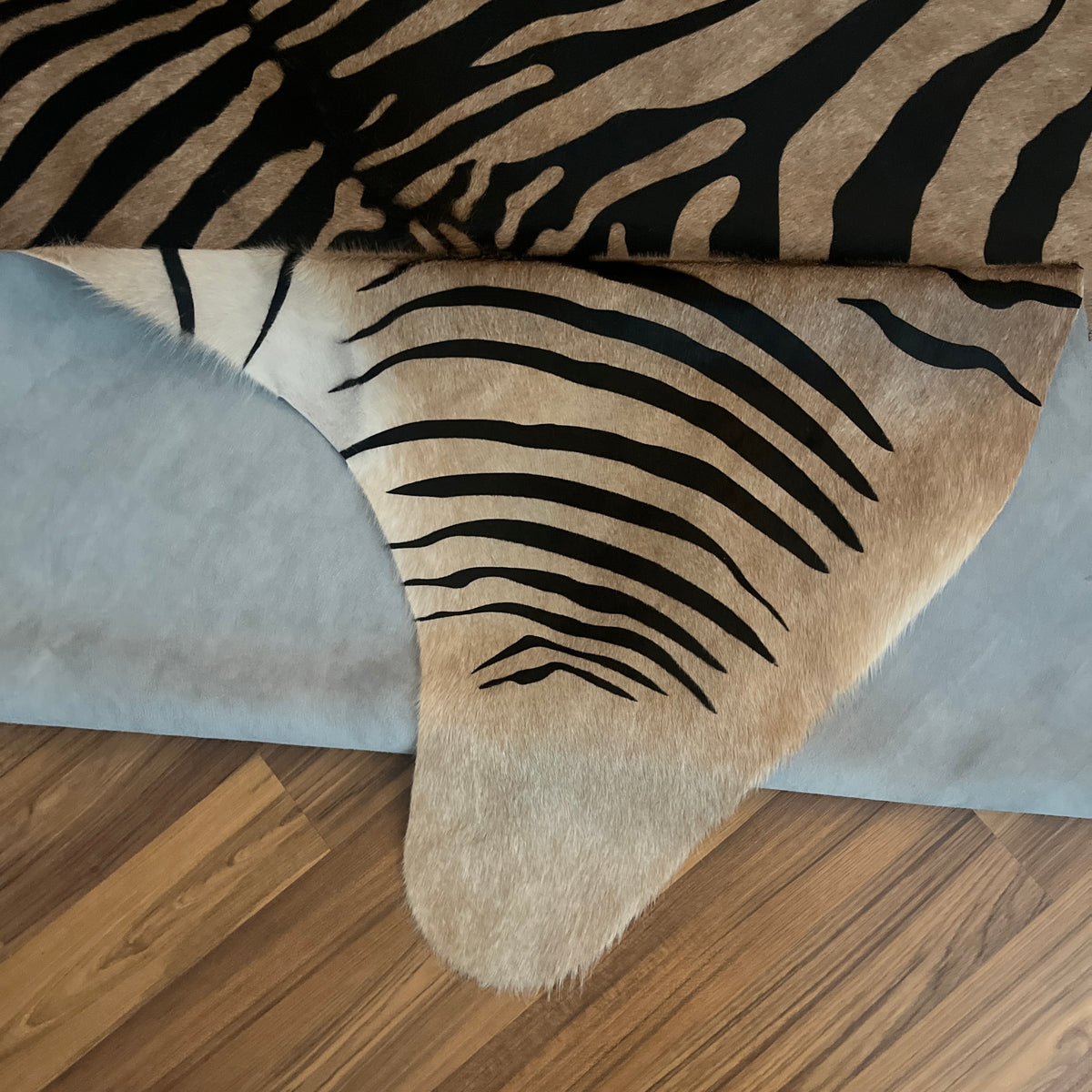 Close-up texture of Black and White zebra print cowhide rug — Bold zebra stripes radiating from center, dark striping over cr