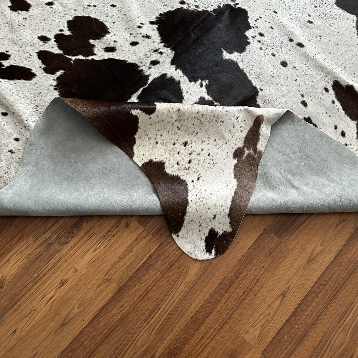 Close-up texture of Black and White cowhide rug — Large irregular black patches and spots over cream and white base