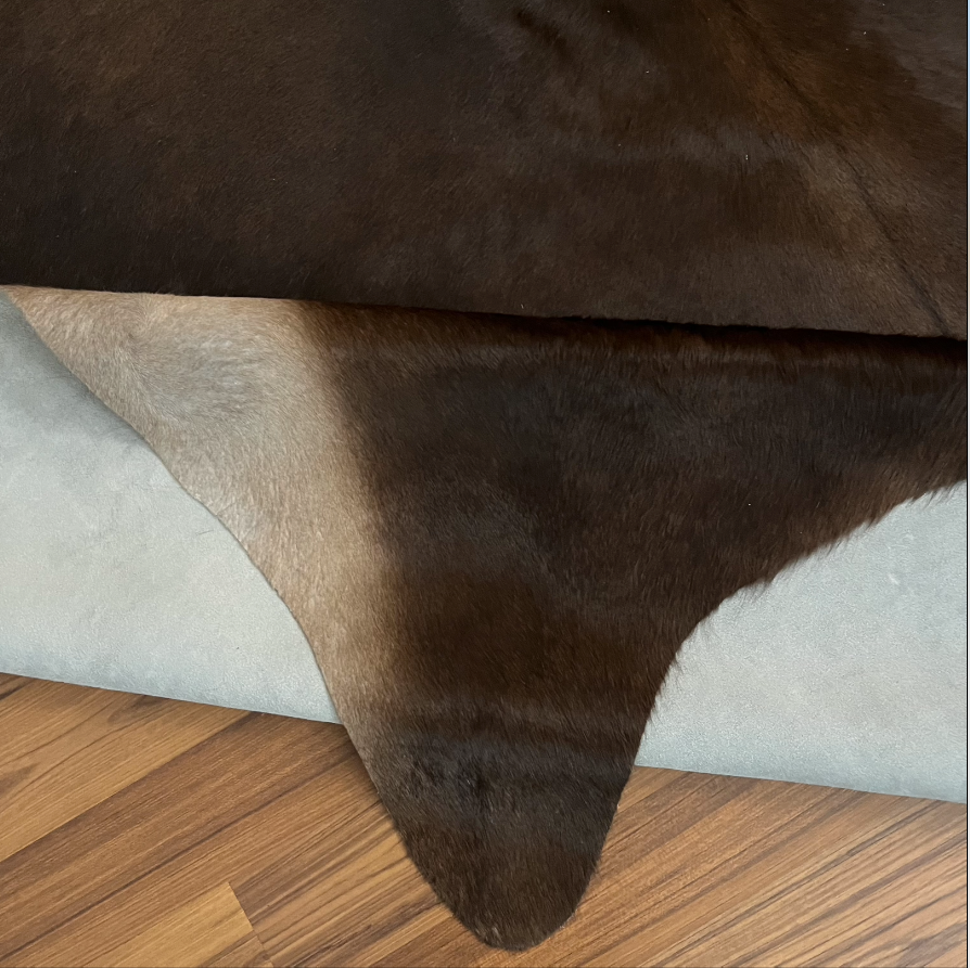 Close-up texture of Black and White cowhide rug — Large irregular dark brown-black patches over cream and white base with nat
