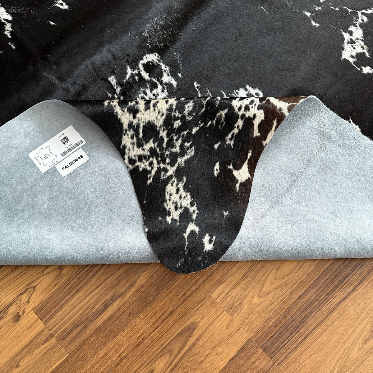 Close-up texture of Black and White cowhide rug — Large irregular white patches and speckles over deep black base