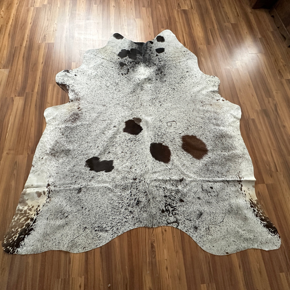 Brown and White cowhide rug, full overhead view — Large irregular dark brown patches over cream and grey base
