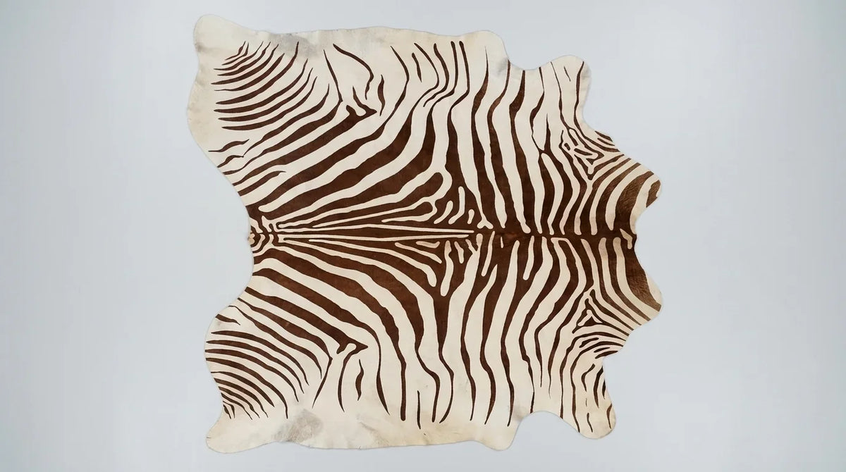 Brown and White cowhide rug flat lay on white background showing full hide shape