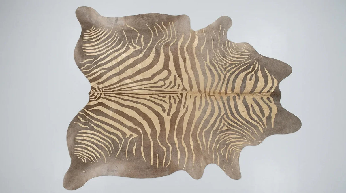 Brown and White cowhide rug flat lay on white background showing full hide shape