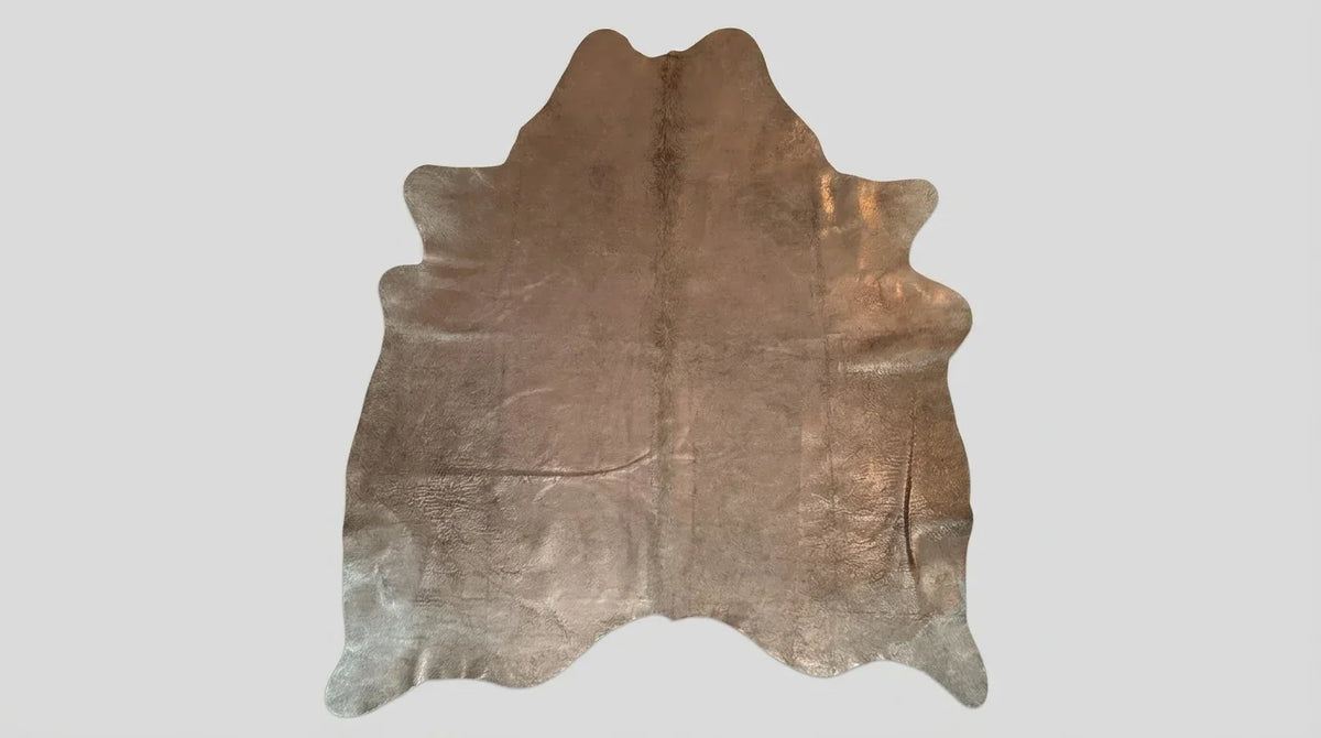 Brown and White cowhide rug flat lay on white background showing full hide shape