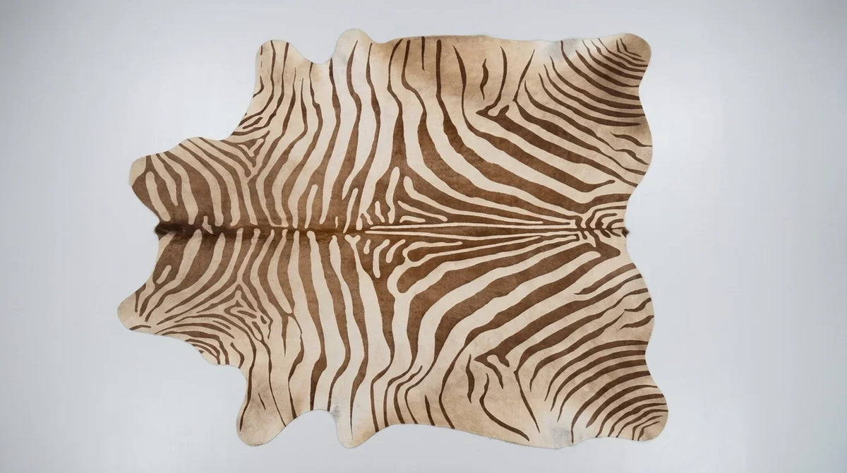 Brown and White cowhide rug flat lay on white background showing full hide shape