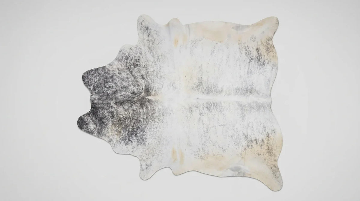 Brown and White cowhide rug flat lay on white background showing full hide shape
