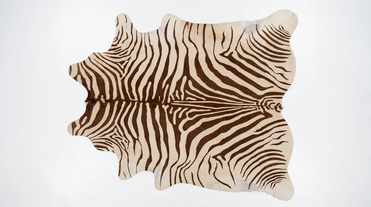 Brown and White cowhide rug flat lay on white background showing full hide shape