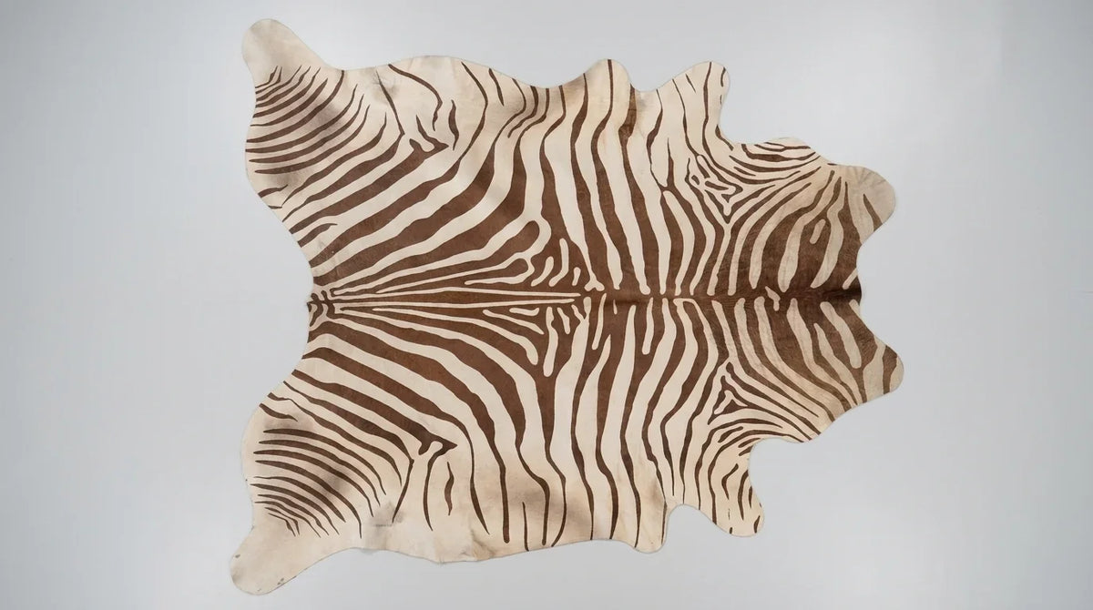 Brown and White cowhide rug flat lay on white background showing full hide shape