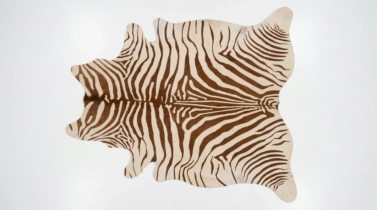 Brown and White cowhide rug flat lay on white background showing full hide shape