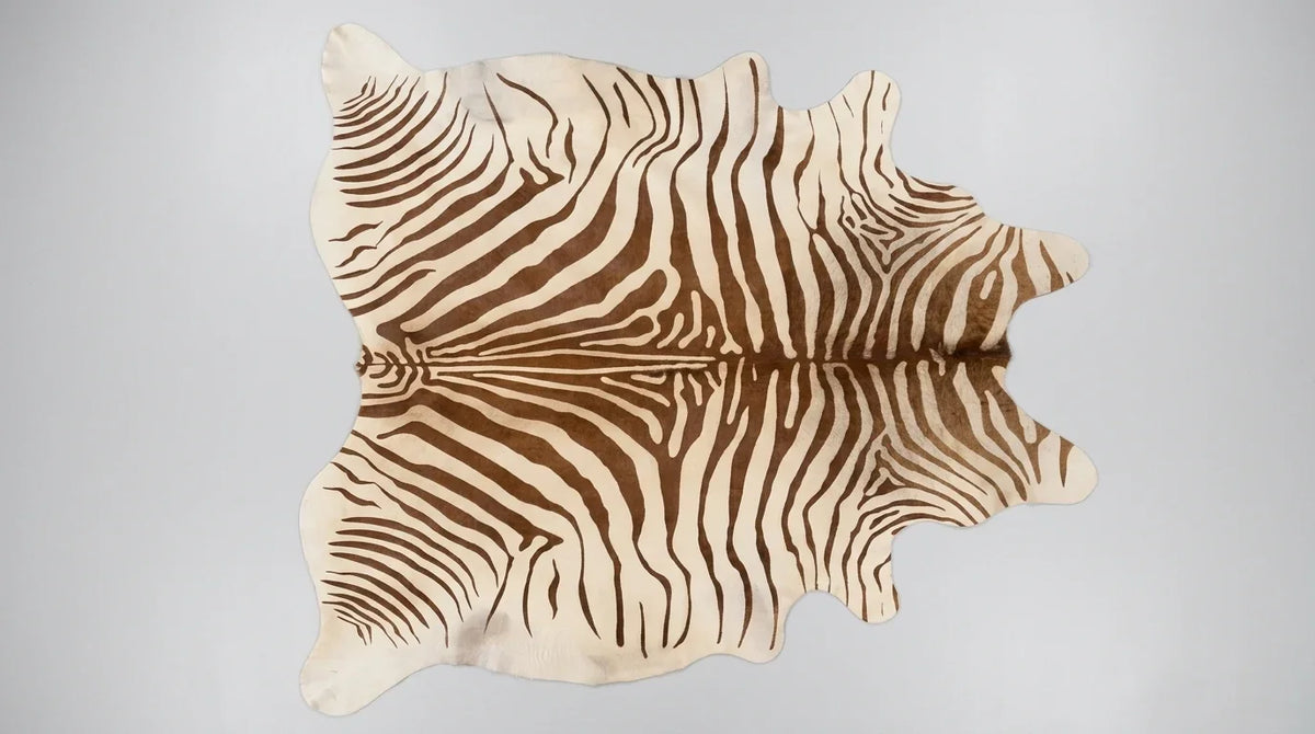 Brown and White cowhide rug flat lay on white background showing full hide shape