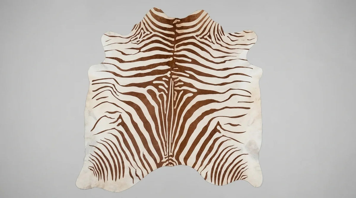 Brown and White cowhide rug flat lay on white background showing full hide shape