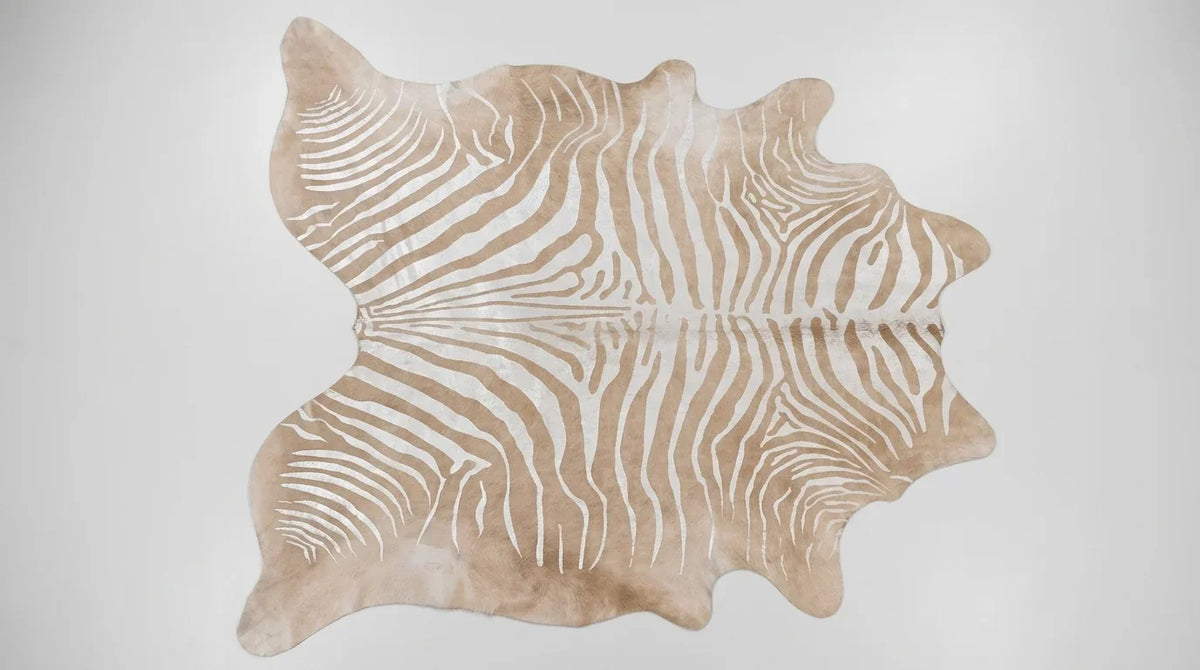 Brown and White cowhide rug flat lay on white background showing full hide shape