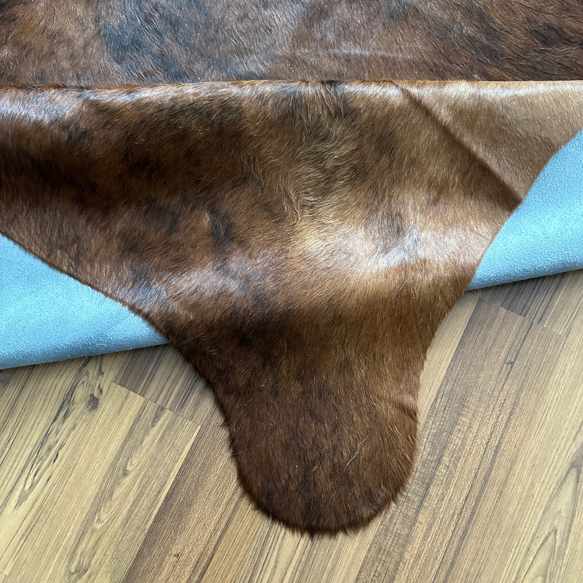 Close-up texture of Brown and White cowhide rug — Large irregular chocolate brown patches with white accents over natural tan