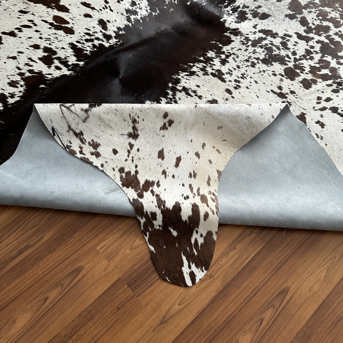 Close-up texture of Brown and White cowhide rug — Large irregular dark brown patches over cream and white base