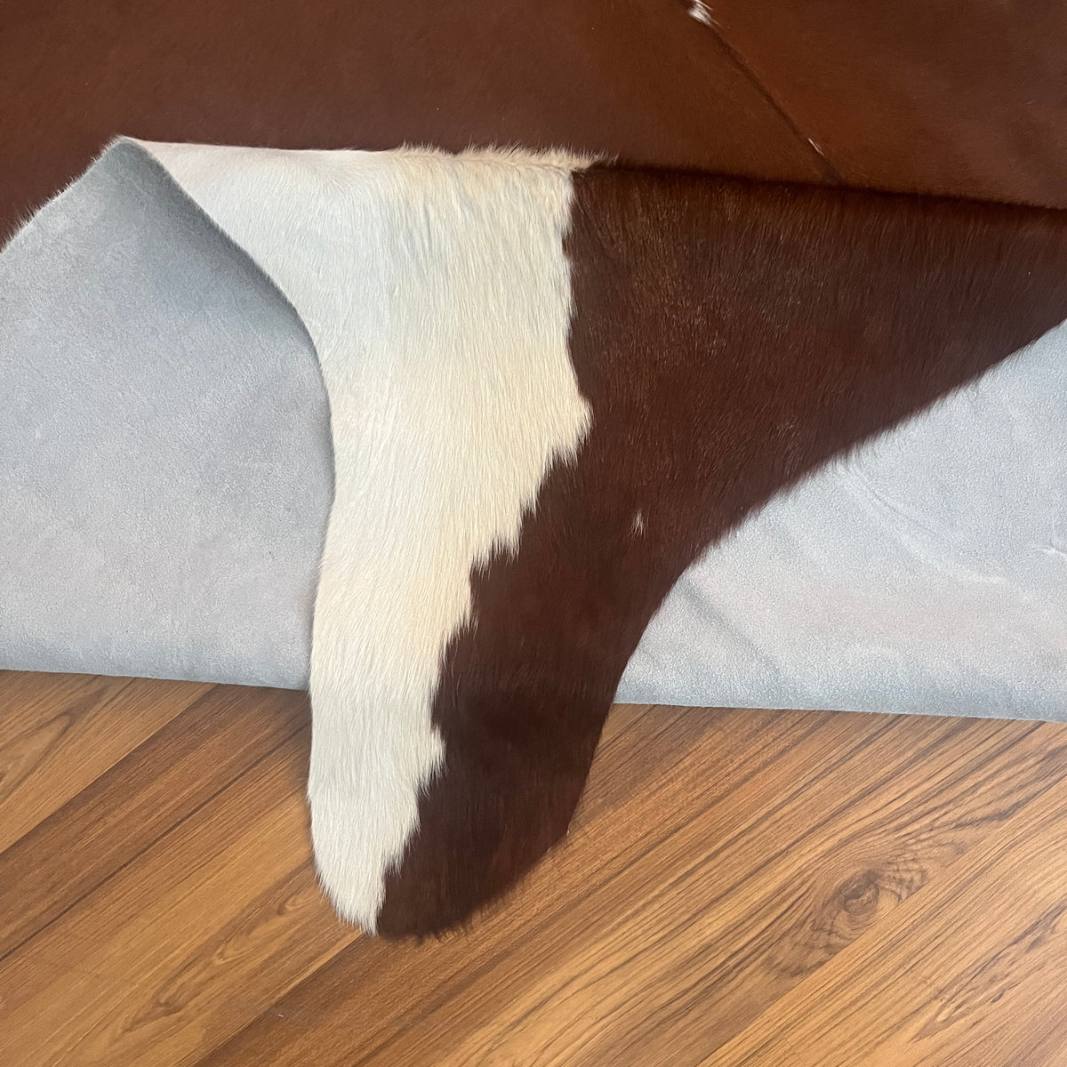 Close-up texture of Brown and White cowhide rug — Large irregular dark brown patches with cream and white base throughout