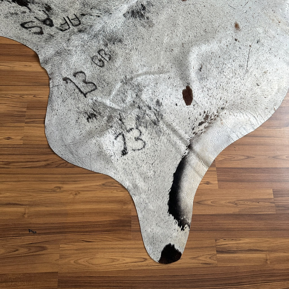 Close-up texture of Brown and White cowhide rug — Large irregular dark brown patches and spots over cream base with natural m