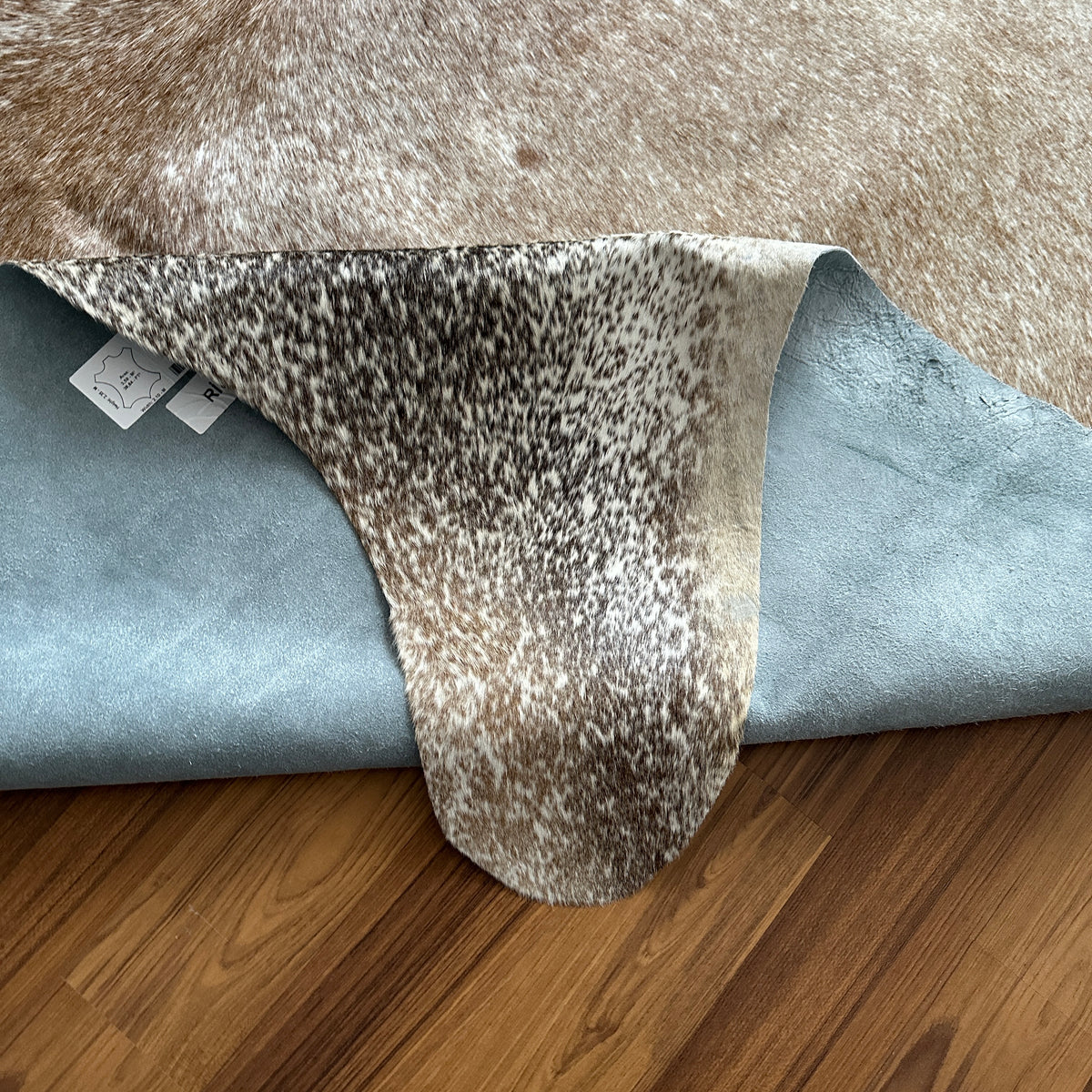 Close-up texture of Brown and White cowhide rug — Large irregular dark brown patches over cream and white base