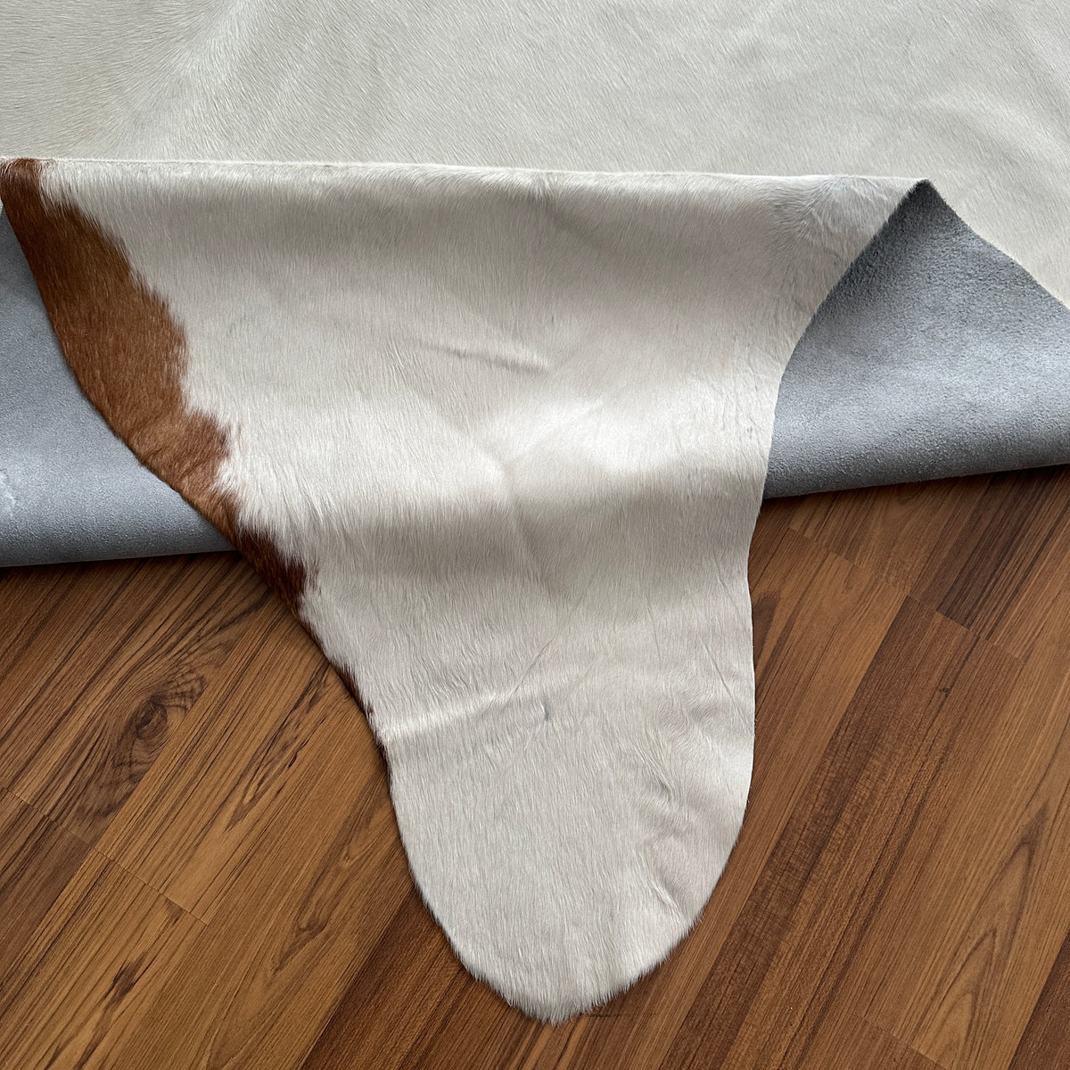 Close-up texture of Brown and White cowhide rug — Large irregular chocolate brown patches over cream-white base