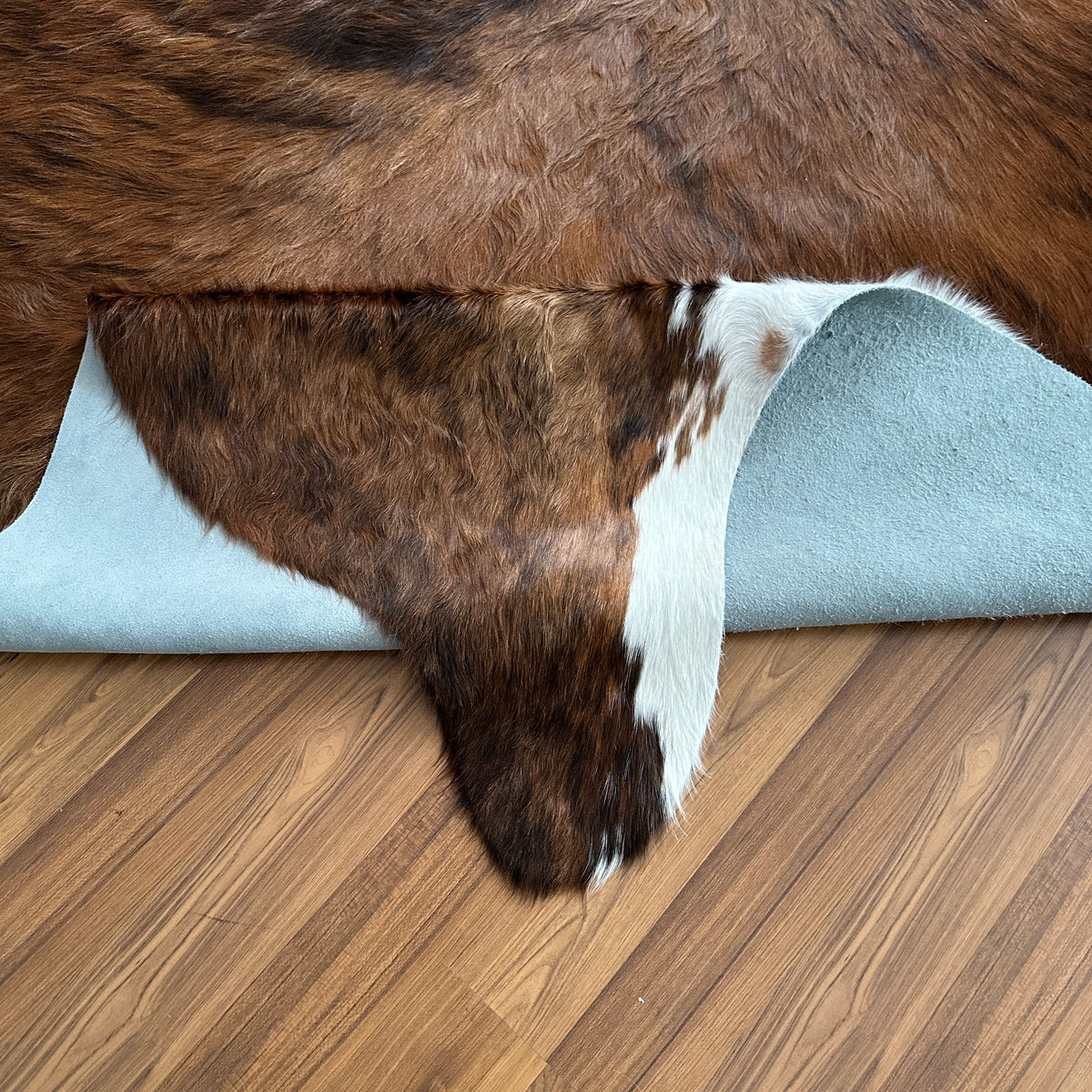 Close-up texture of Brown and White cowhide rug — Large irregular dark brown patches over lighter tan and cream base with whi