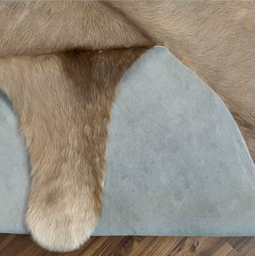 Close-up texture of Brown and White cowhide rug — Large irregular chocolate brown patches over cream and white base