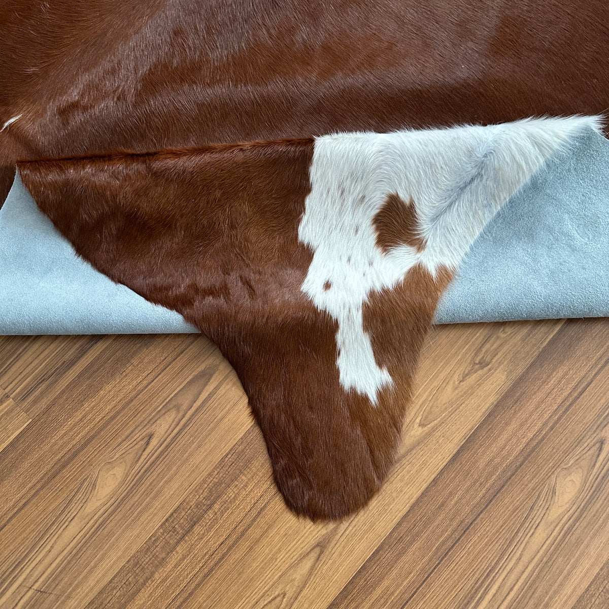 Close-up texture of Brown and White cowhide rug — Large irregular white patches on dark chocolate brown base with white accen