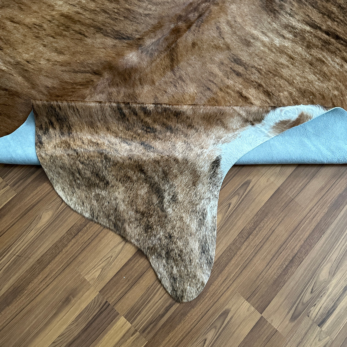 Close-up texture of Brown and White cowhide rug — Large irregular chocolate-brown patches over cream and white base