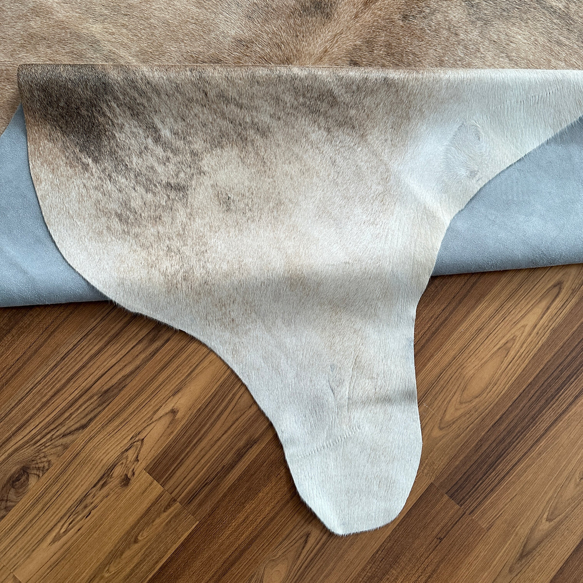 Close-up texture of Brown and White cowhide rug — Large irregular brown patches over cream and white base