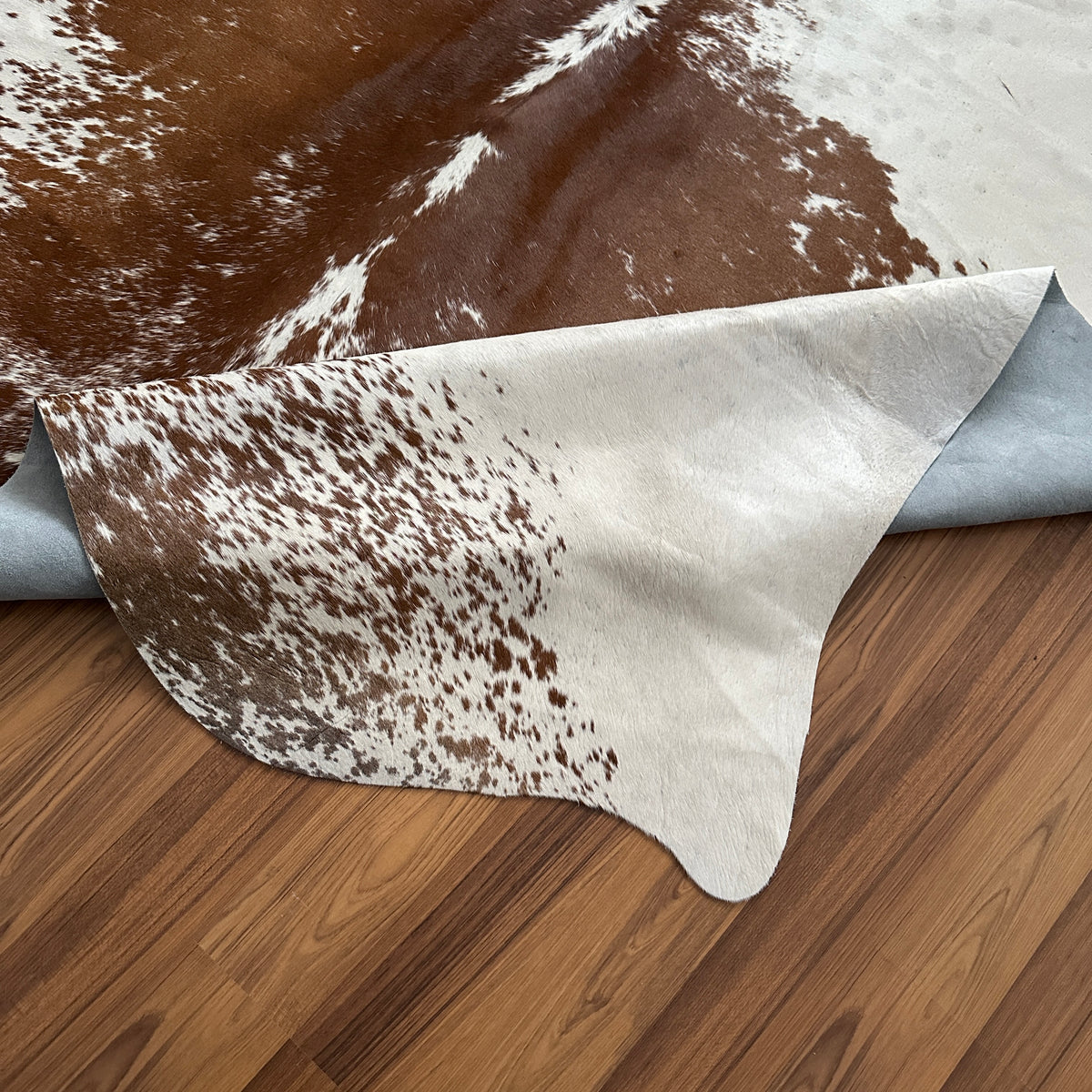 Close-up texture of Brown and White cowhide rug — Large irregular chocolate brown patches over cream and white base