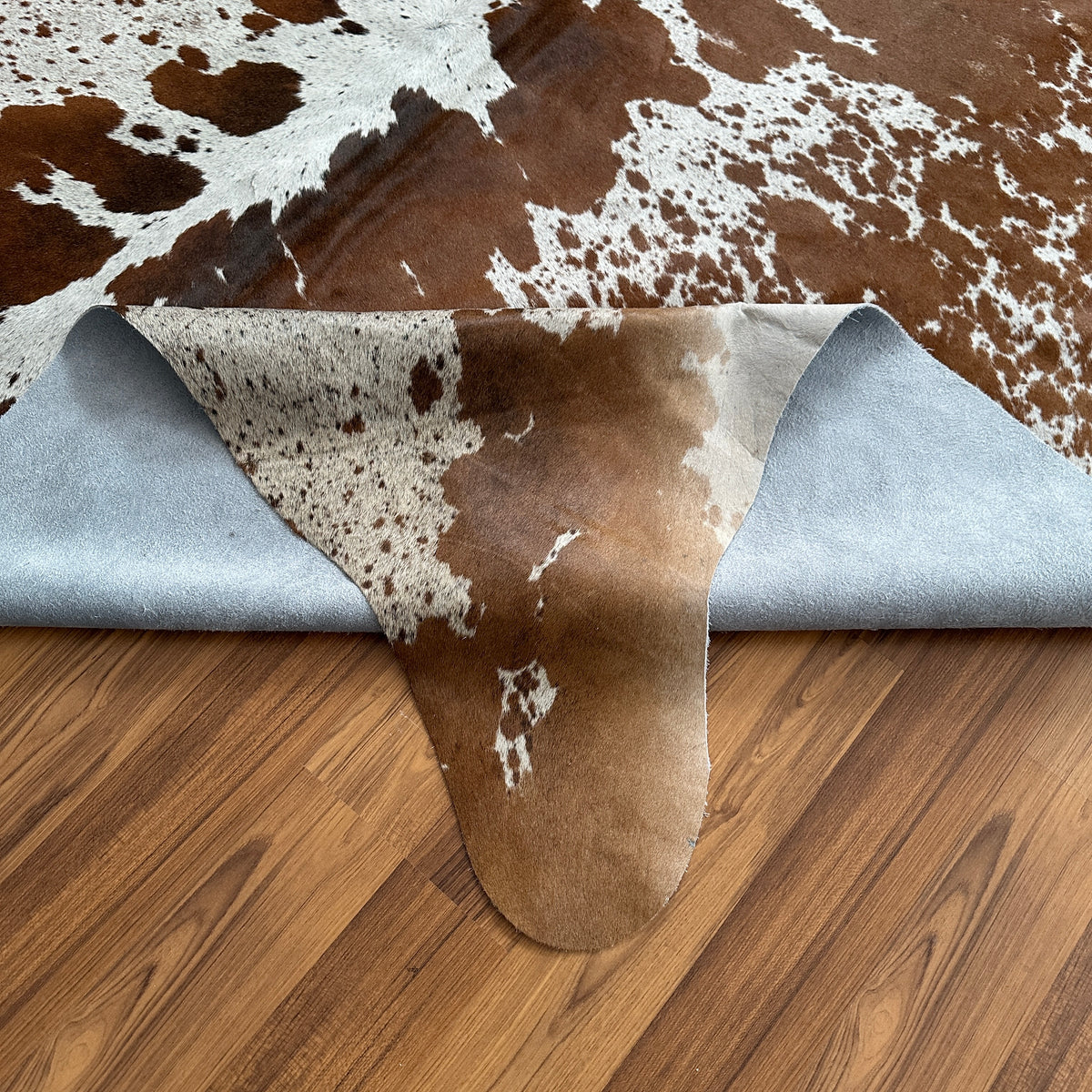 Close-up texture of Brown and White cowhide rug — Large irregular chocolate brown patches over cream and white base