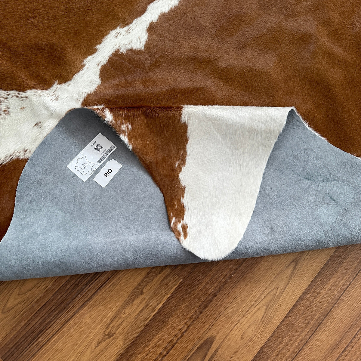 Close-up texture of Brown and White cowhide rug — Large irregular chocolate brown patches with white undersides and belly mar