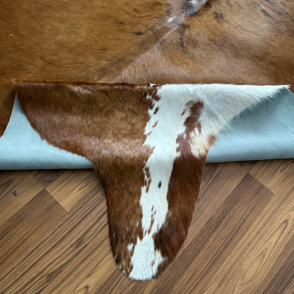 Close-up texture of Brown and White cowhide rug — Large irregular chocolate brown patches with white markings and a distincti