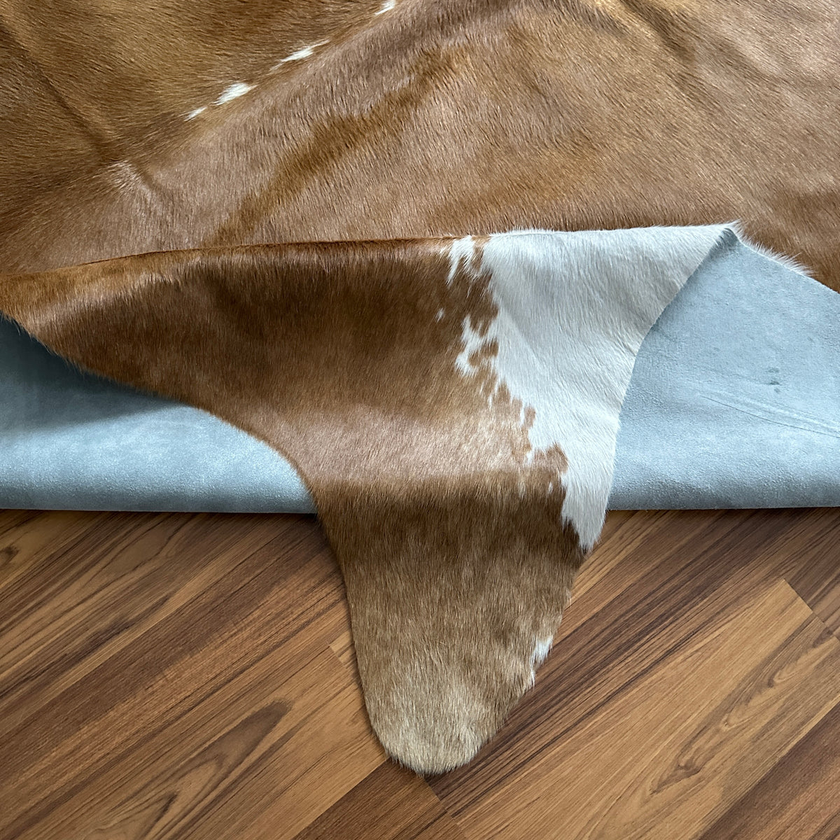 Close-up texture of Brown and White cowhide rug — Large irregular chocolate brown patches with cream and white base