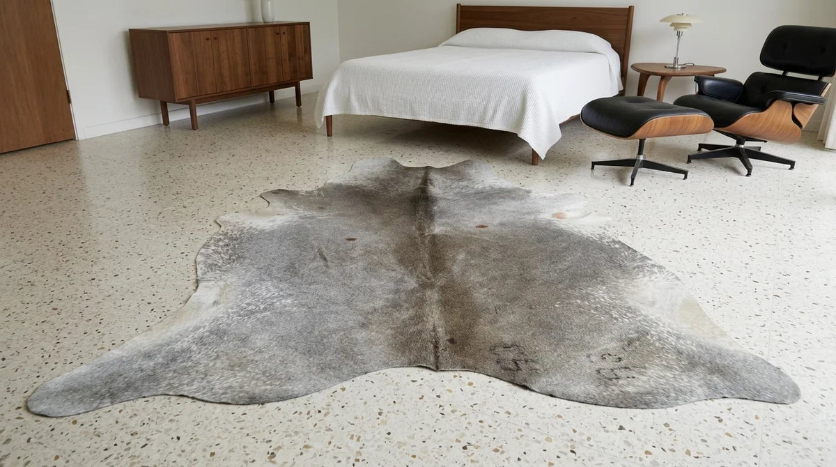 Grey cowhide rug beside bed in midcentury modern bedroom