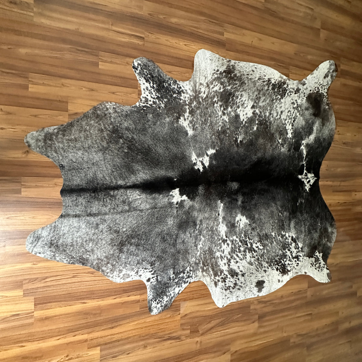 Grey cowhide rug, full overhead view — Large irregular dark grey and white patches with fine speckled overlay