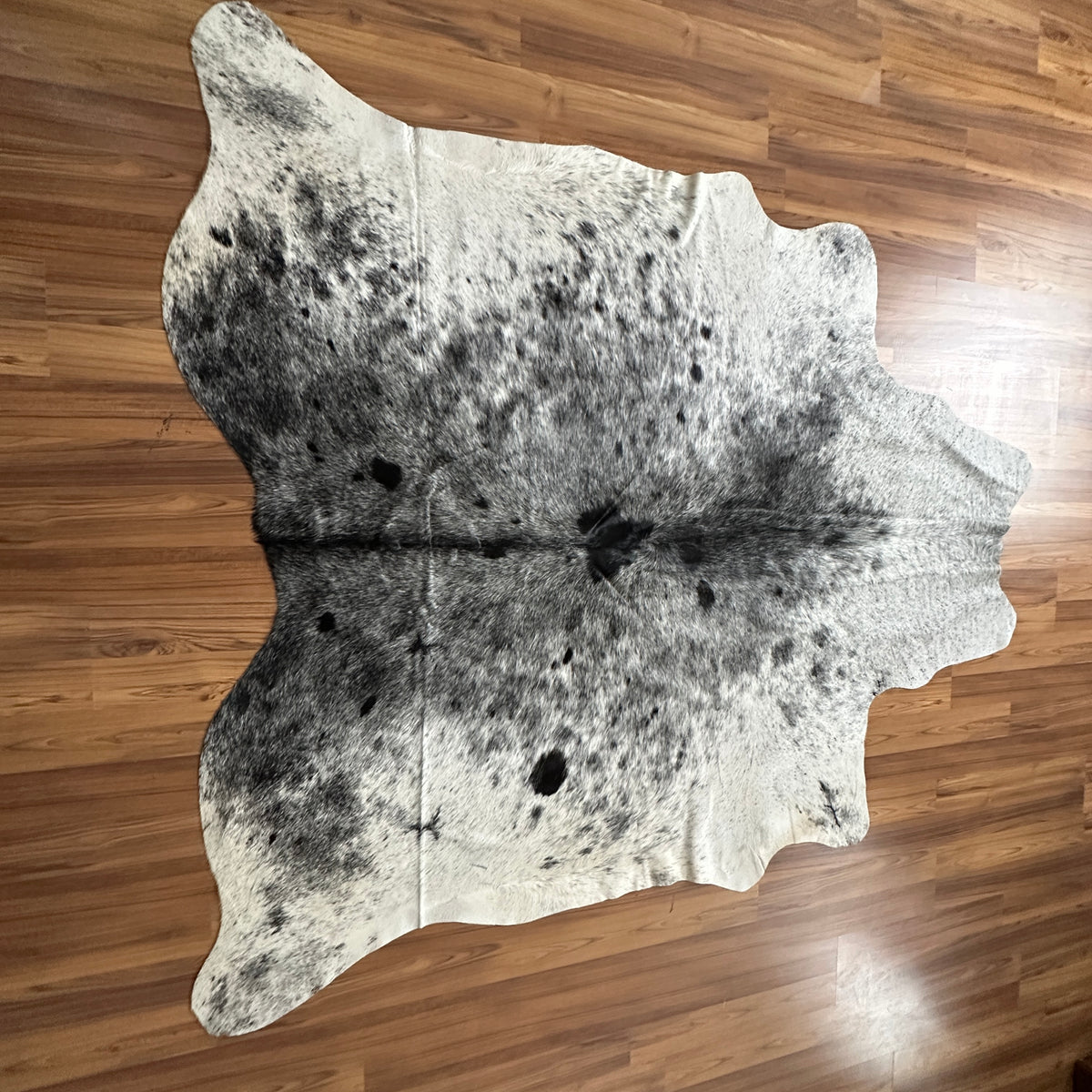Grey cowhide rug, full overhead view — Fine salt and pepper speckle with darker grey patches over light cream base