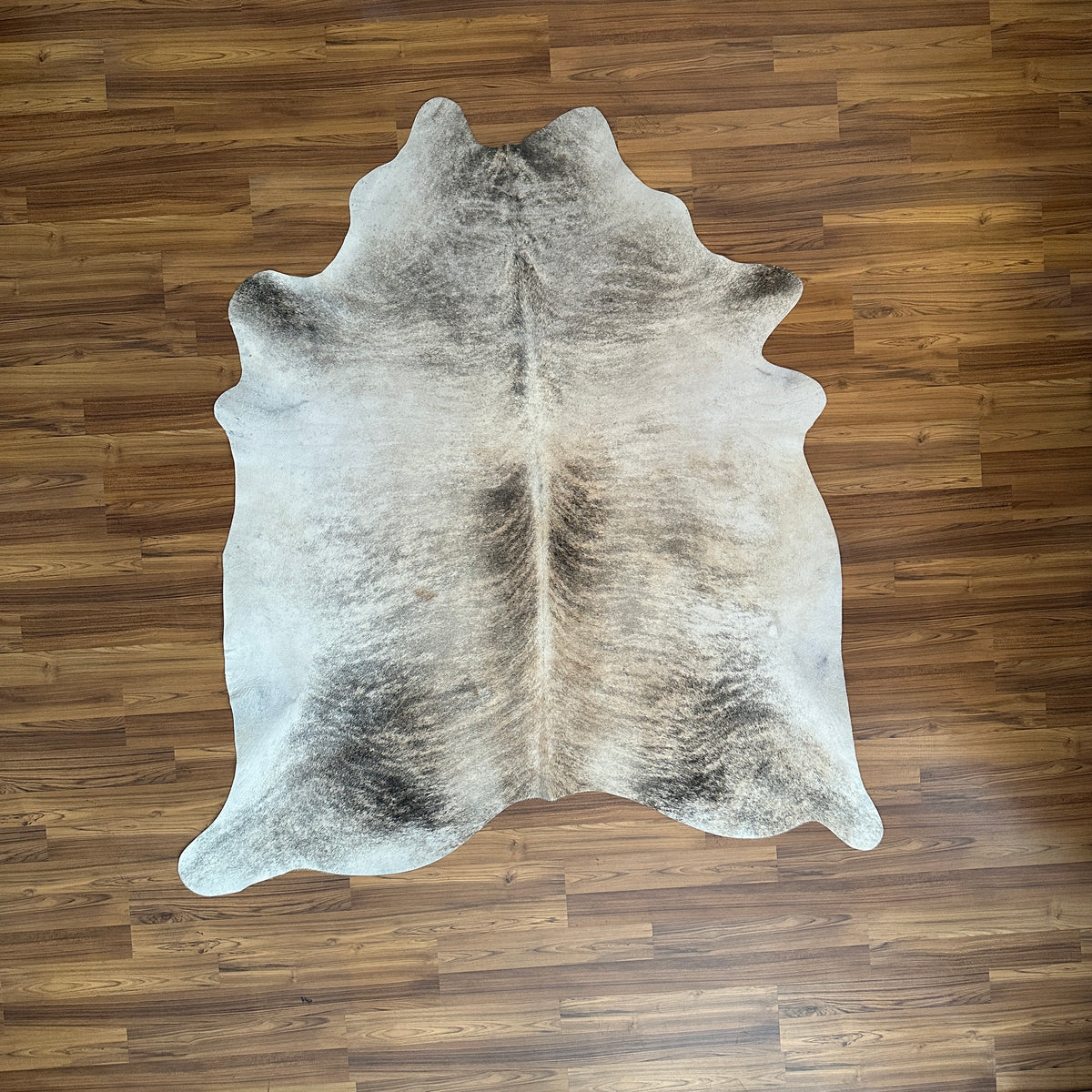 Grey cowhide rug, full overhead view — Large irregular charcoal and cream patches with natural hide variation