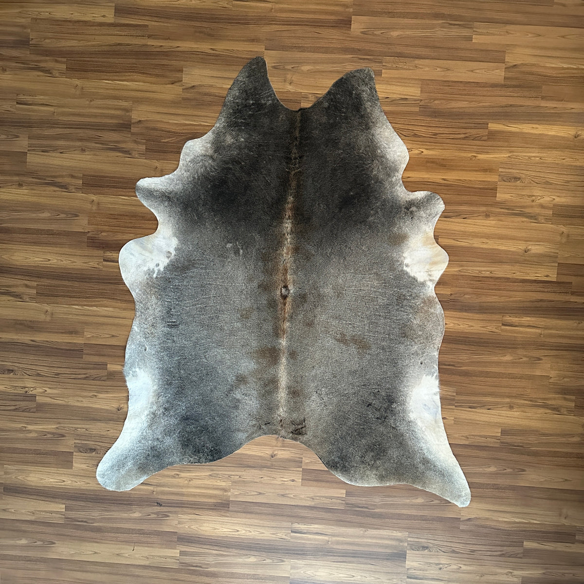 Grey cowhide rug, full overhead view — Large irregular dark grey and charcoal patches over light grey and cream base
