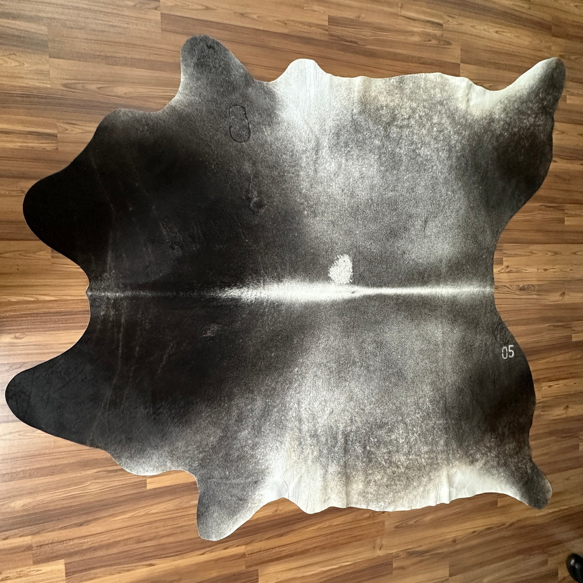 Grey cowhide rug, full overhead view — Large irregular patches in charcoal and cream tones over a grey base