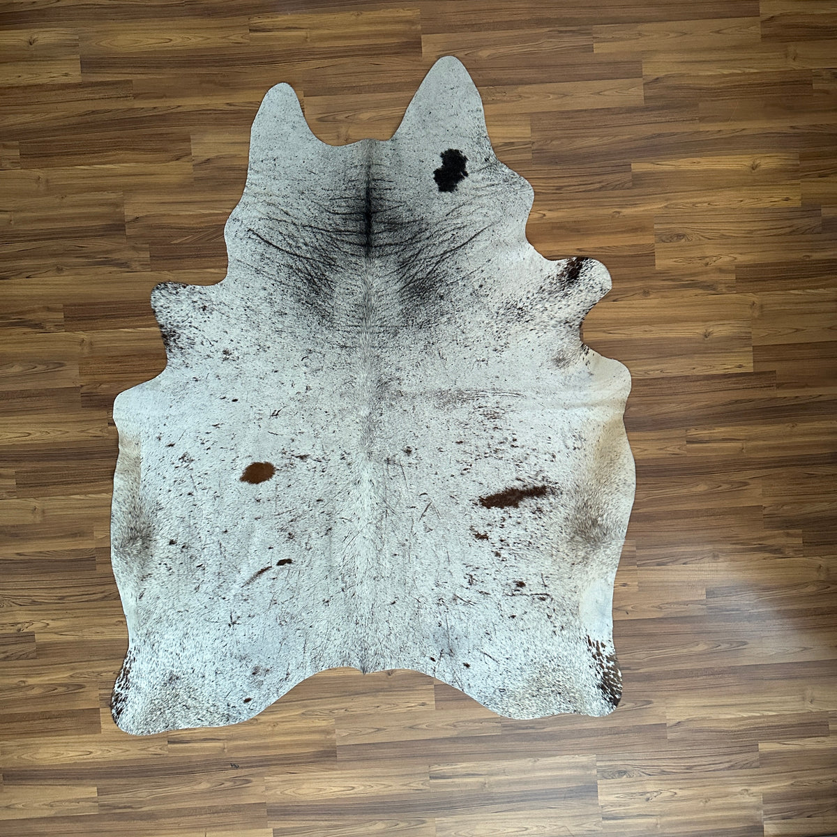 Grey salt and pepper cowhide rug, full overhead view — Fine even speckle of dark and light hairs throughout, with darker patc