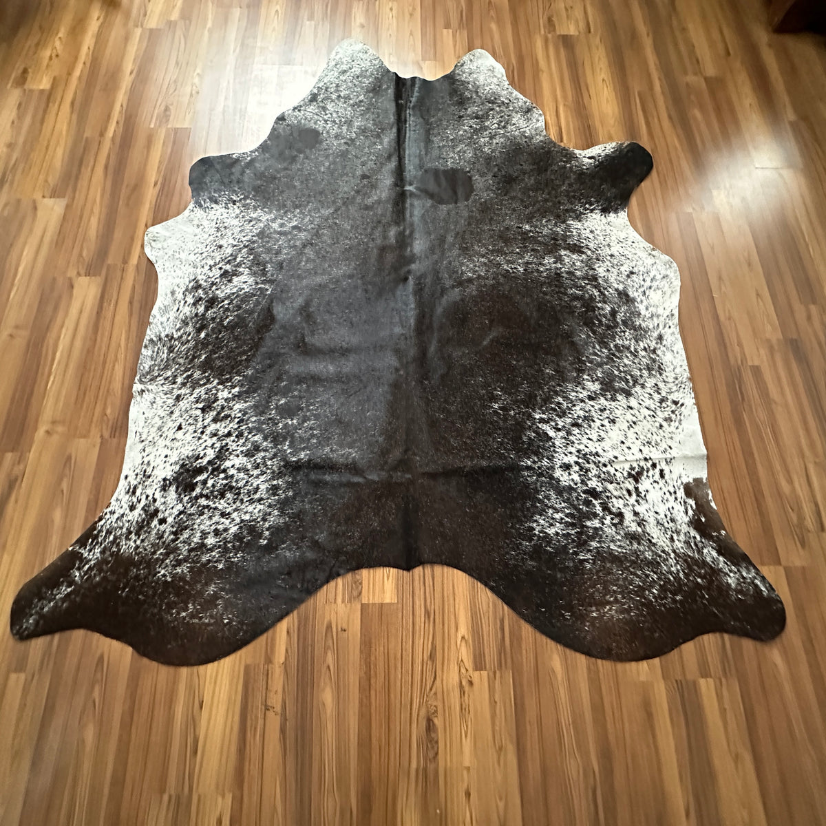 Grey salt and pepper cowhide rug, full overhead view — Fine even speckle of dark and light hairs throughout, creating a peppe