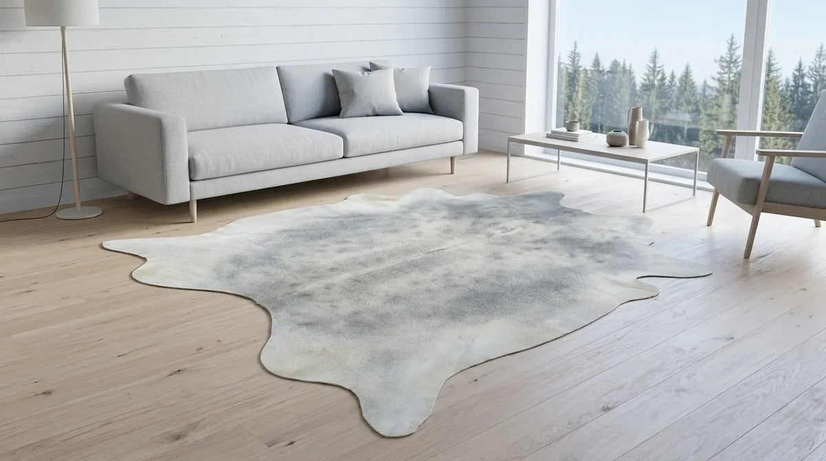 Grey cowhide rug on hardwood floor in scandinavian cabin living room