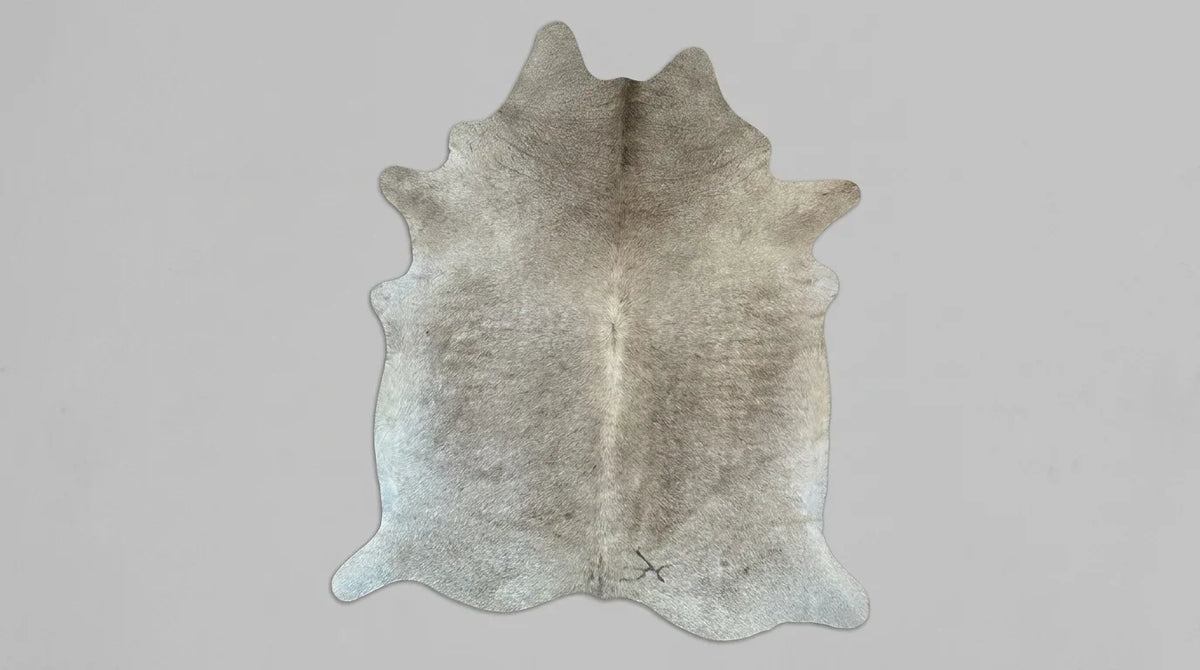 Grey cowhide rug flat lay on white background showing full hide shape