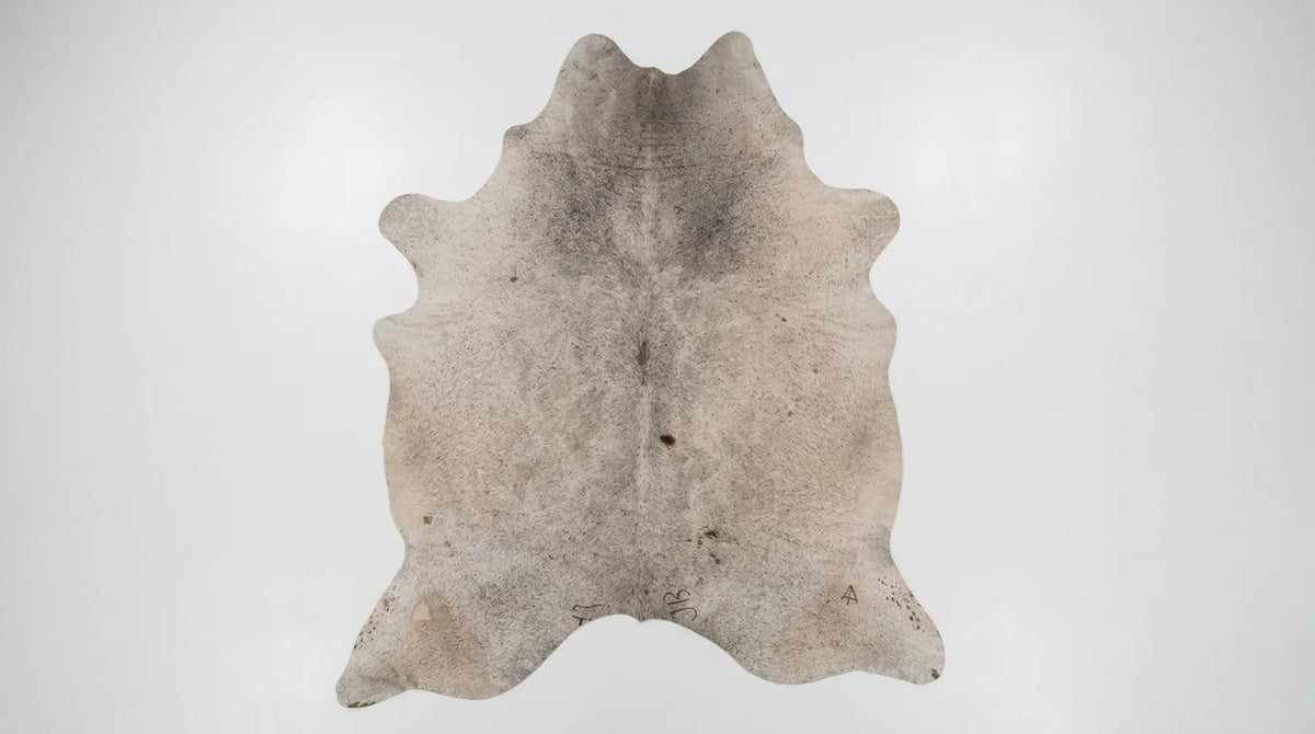 Grey cowhide rug flat lay on white background showing full hide shape
