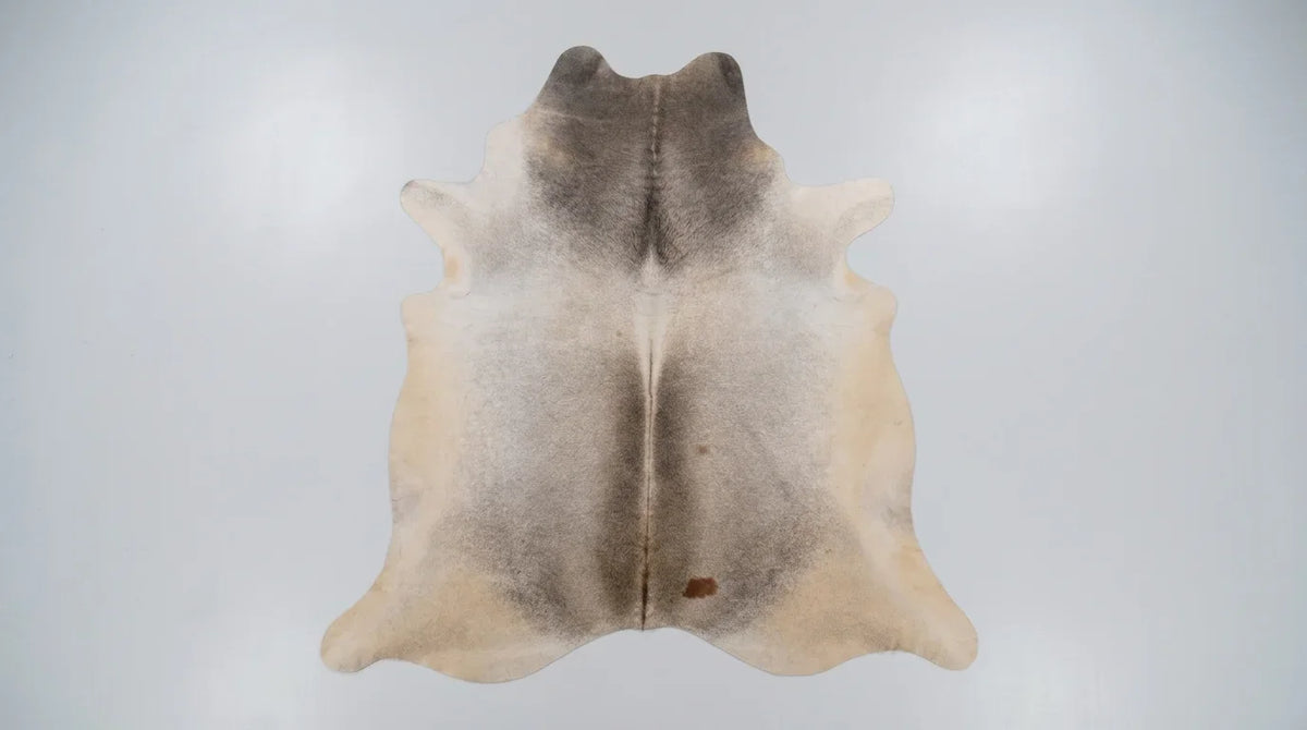 Grey cowhide rug flat lay on white background showing full hide shape