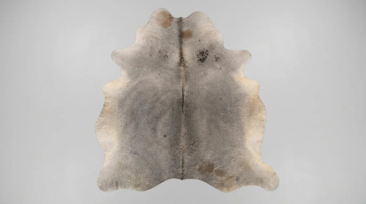 Grey cowhide rug flat lay on white background showing full hide shape