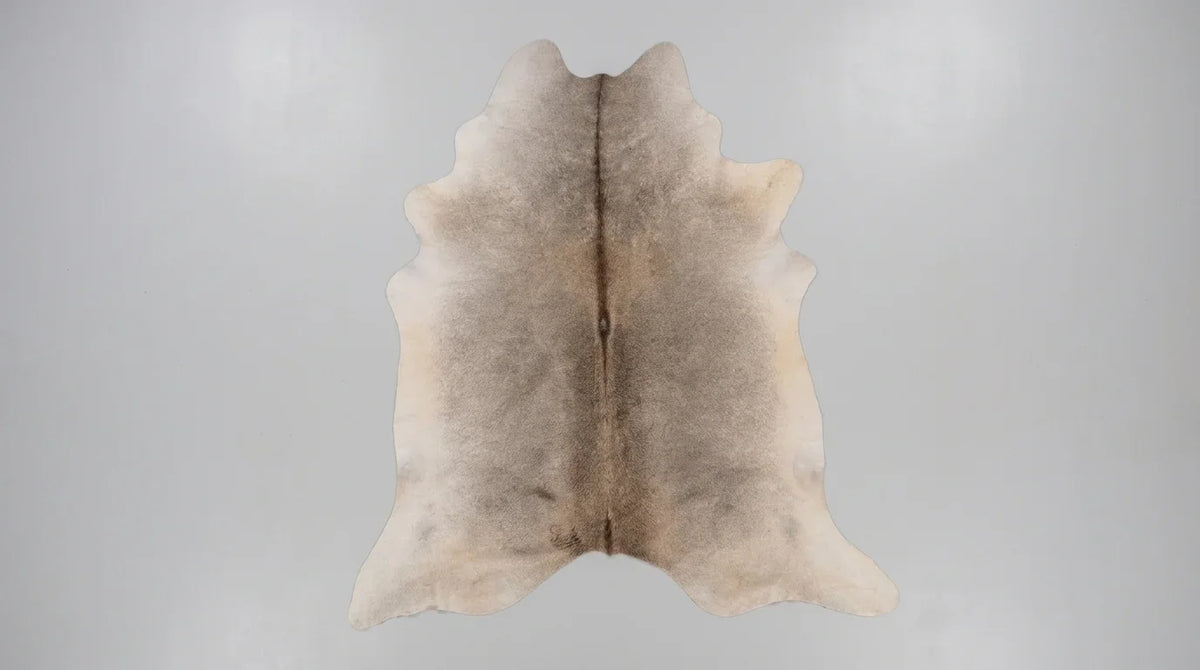 Grey cowhide rug flat lay on white background showing full hide shape