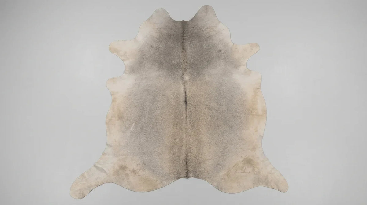 Grey cowhide rug flat lay on white background showing full hide shape