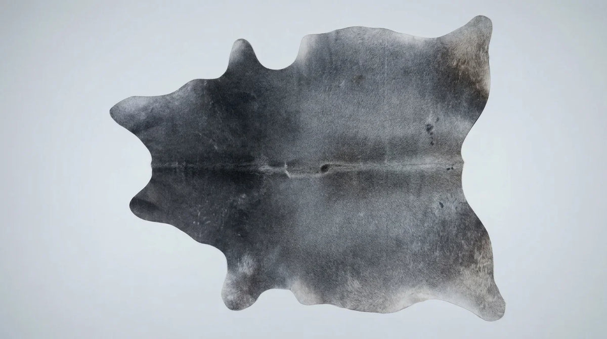 Grey cowhide rug flat lay on white background showing full hide shape